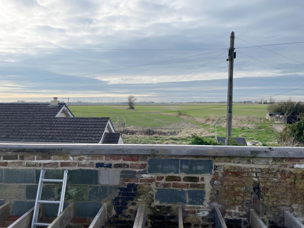Lot: 101 - COTTAGE RENOVATION PROJECT WITH PLANNING IN VILLAGE LOCATION - View over the Fens to the front of the cottage in Upwell